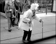 Old woman with stick crossing road Exeter GX7 P1140316.JPG